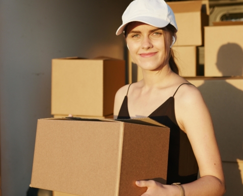 female-delivery-driver-holding-cardboard-boxes