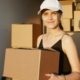 female-delivery-driver-holding-cardboard-boxes