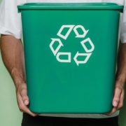 man-holding-green-bin-with-recycling-symbol-on